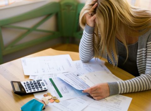 mujer frustrada calculando su presupuesto