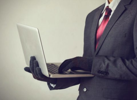 man with gloves using a computer