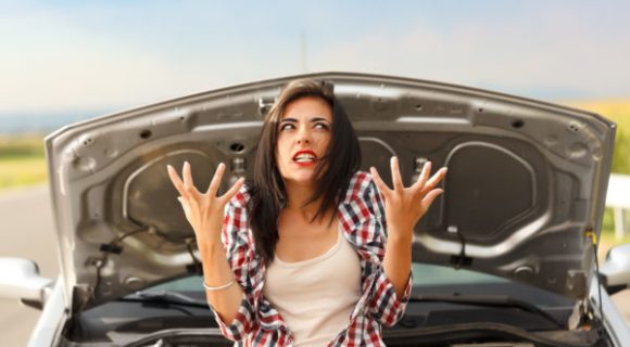 woman frustrated in front of her car