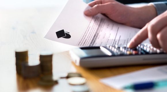 person reading student loan paperwork while using a calculator