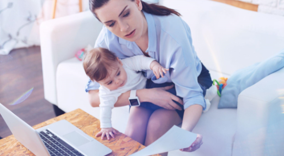 woman looking at credit report while holding a baby