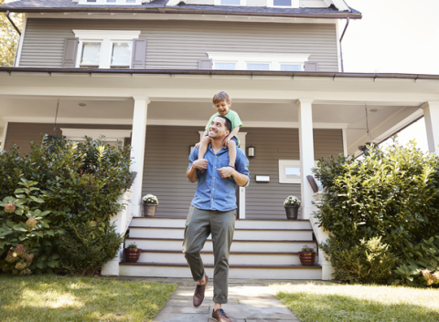 Father Giving son ride on shoulders outside home