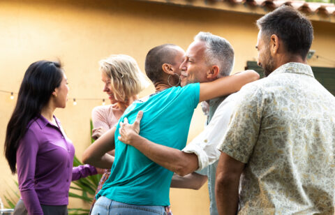 Friends arriving to garden dinner party. Hosts welcoming guests.