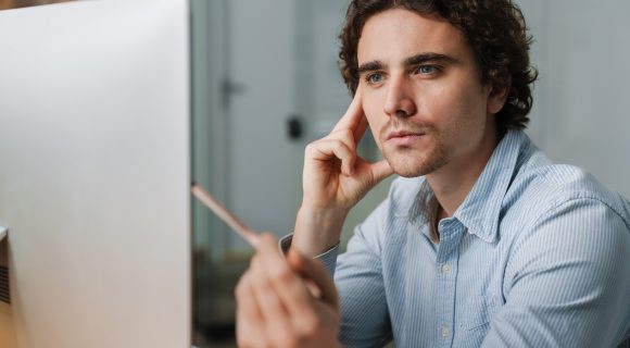 Confident young busy entrepreneur sitting at the office desk