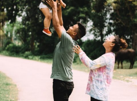man and woman playing with child
