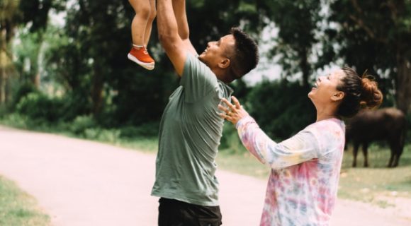 man and woman playing with child