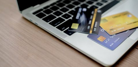Multiple credit cards scattered on a laptop keyboard