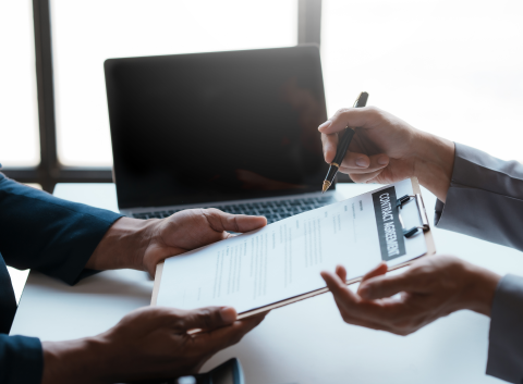Close-up of two professionals discussing and signing a contract agreement