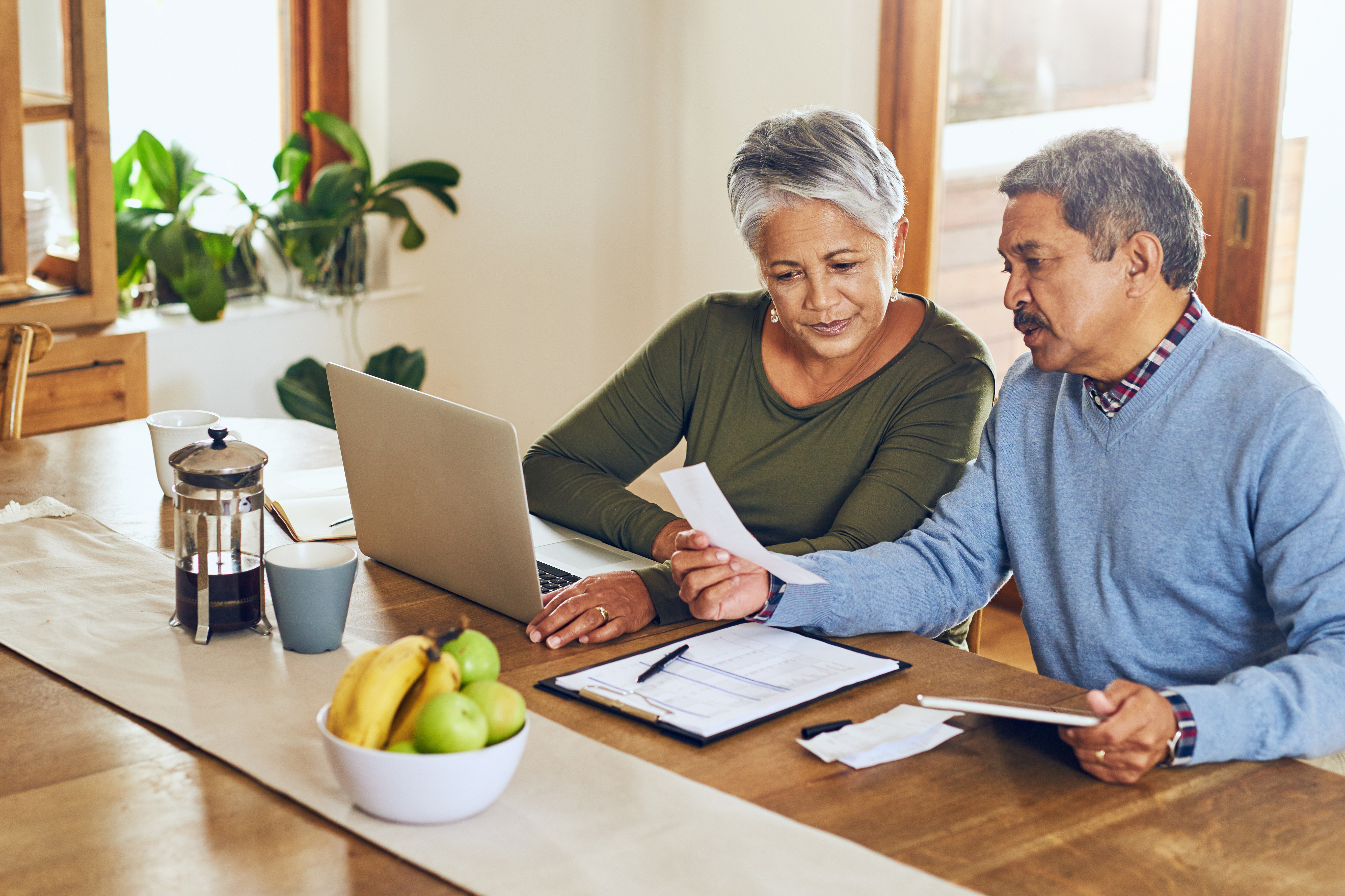 Older couple looks at bills and budget worksheet