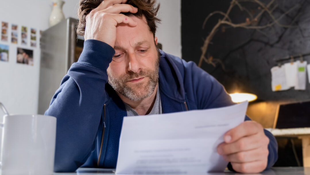 tired man looking at a bill