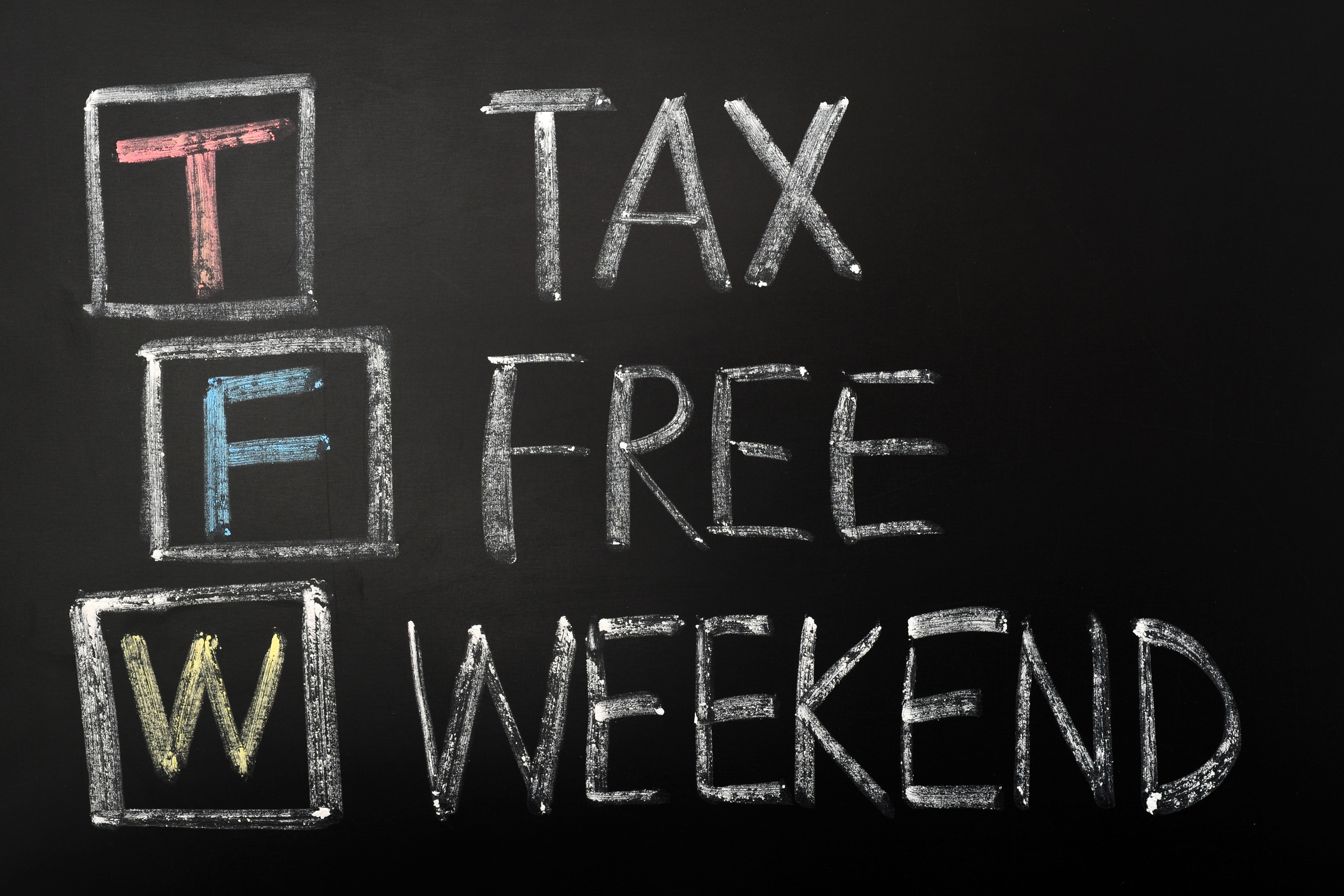 A chalkboard sign displaying "Tax-Free Weekend" in bold, hand-drawn lettering