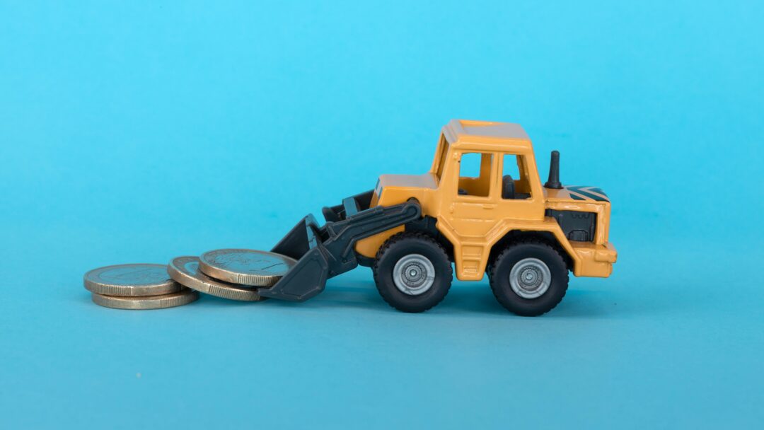Miniature construction vehicle moving coins