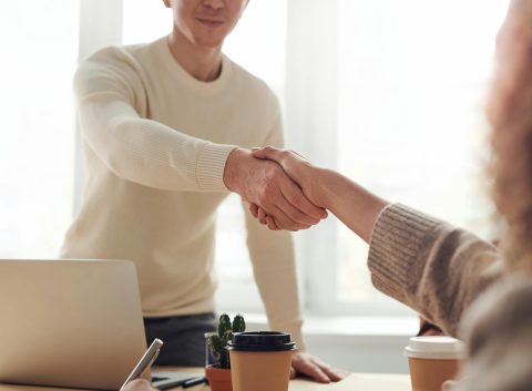 Two people shaking hands in an office setting