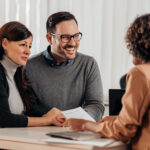 Smiling couple meeting with a professional advisor at a desk