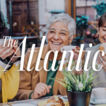Lively café scene with three women chatting and smiling, holding coffee cups and pastries, branded with The Atlantic logo.
