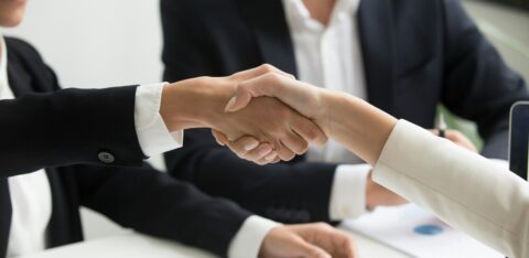 Close-up of a professional handshake between two people in business attire